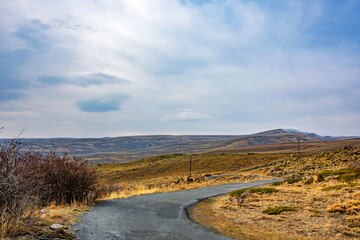 A road winds through a dry, barren landscape