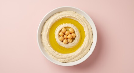 Hummus bowl with olive oil on pink