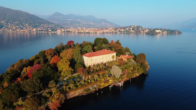 Aerial view of Isola Madre with its historic palace amid lush autumnal foliage, reflecting in the serene waters of Lake Maggiore, Isola Madre, Stresa, Italy.