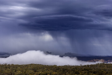 Thunder storm cell over Blue Mountains, fog rising from valley