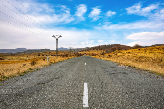 A road with a power line pole in the middle