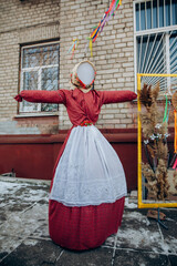 Maslenitsa scarecrow in traditional dress outdoors
