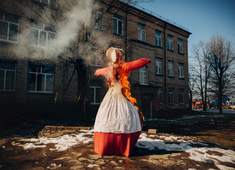 Burning Maslenitsa scarecrow in traditional Slavic attire