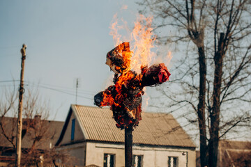 Burning Maslenitsa scarecrow in traditional Slavic attire