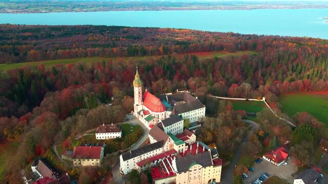 Aerial view of Andechs Abbey showing the architecture with red roofs and the surrounding autumn trees, Andechs, Bayern, Germany.