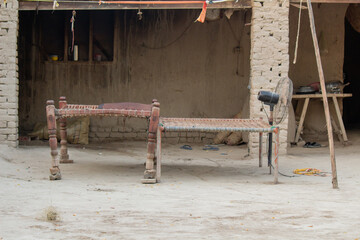Traditional Village Charpai and Outdoor Seating Area in a Rural Mud House Courtyard
