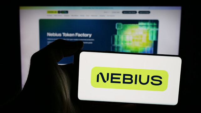 Stuttgart, Germany - 11-06-2025: Person holding mobile phone with logo of AI infrastructure company Nebius Group N.V. on screen in front of web page. Focus on phone display.