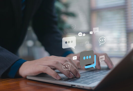 Businessman typing on laptop with digital chat bubbles, representing online communication, messaging, customer support, social interaction, and modern digital connection.