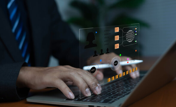 Businessman working on laptop with futuristic digital dashboard interface, representing data analytics, technology management, cybersecurity, and modern business innovation in the digital era.