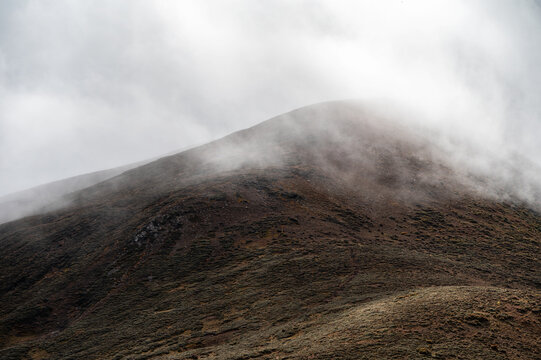 A mountain peak shrouded in mist in the early morning - Powered by Adobe
