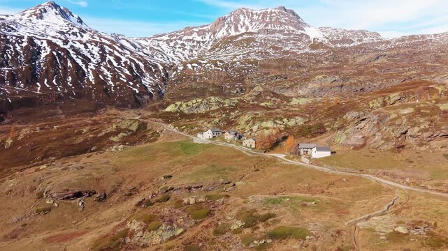 Aerial view of the Simplon Hospice with snow-capped mountains, a stark contrast to the rugged terrain of Simplonpass, Wallis, Switzerland.