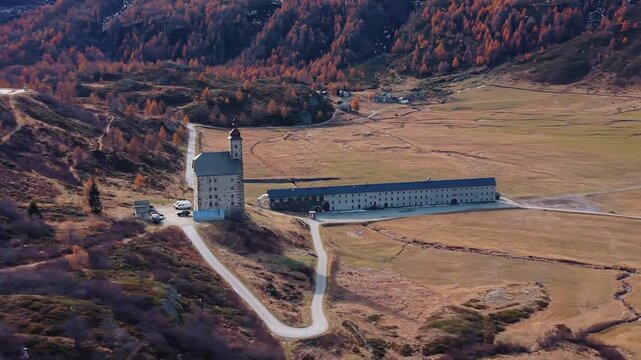 Aerial view of the Simplon Hospice, a striking building amidst the Wallis landscape, set against a backdrop of autumnal colors, Simplon Hospice, Wallis, Switzerland.