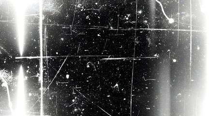 Abstract grunge texture with scratches and dust particles on a black background, creating a vintage or distressed film effect with bright light flares on the side