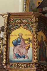 Religious icon of Saint Zosima in the Panagia Tourliani Monastery in Mykonos, painted on a wooden panel and framed by elaborate gold and multicolored carvings