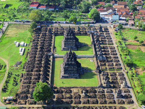 Aerial view of the ancient Plaosan Temple complex stands in stark contrast to the lush green grass within its stone walls, Klaten Regency, Jawa Tengah, Indonesia.