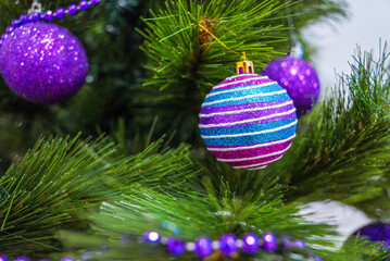 Beautiful purple Christmas balls on an artificial Christmas tree. Christmas decoration.