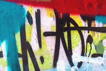 Urban graffiti art features bold black tags on wall with vibrant splash of neon red, blue, yellow. Elements of 90s, retro street style, and grunge texture. Posters, urban art, digital backgrounds.