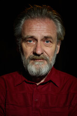 Older man in red shirt waiting for something on night city location