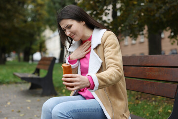 Fototapeta premium Young woman with bun suffering from nausea outdoors