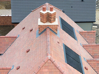 Interesting drone view of a new roof showing a pair of fake chimney pots on top of the new tiled roof. Seen with solar panels, this set-detached home will soon be up for sale.