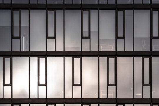 A modern facade where architecture blends geometry with minimal structure, revealing abstract detail and subtle texture in a patterned exterior captured during calm daylight with soft reflections
