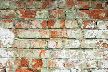 A dilapidated old red brick wall painted white as an abstract background.