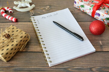 Christmas Wish List Planning on a Wooden Table decorated with christmas ornaments