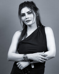 Monochrome studio portrait of an elegant woman wearing a black dress. A confident and modern fashion image symbolizing timeless style and grace.