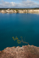 Autumn Landscape with Branch Overlooking Deep Blue Quarry Water from Chalk Cliff, Belarus