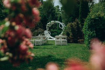 Beautiful outdoor wedding ceremony setup with floral decor and chairs in lush garden