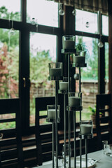 Elegant candle holder centerpiece in modern dining room with large windows