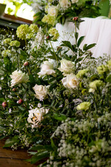 Lush green and white floral arrangement with roses and foliage