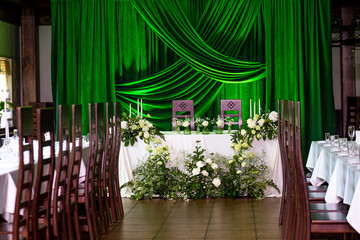 Elegant wedding reception with green drapes and floral arrangements