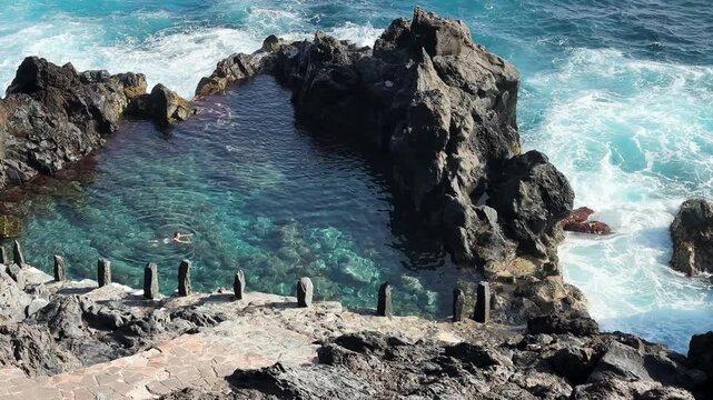 Woman swimming in natural rock pool in Atlantic ocean, Canarias Tenerife