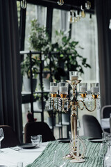Elegant indoor dining room with gold candelabra and green decor