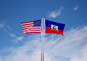 flags of haiti and United States of America over blue sky background.
