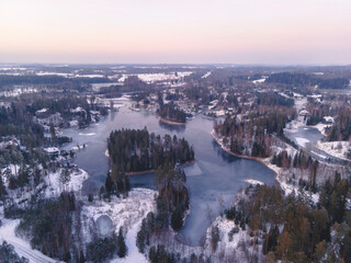 A wintery aerial view reveals frozen lakes, tree-covered islands