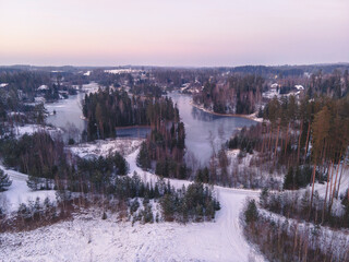 A wintery aerial view reveals frozen lakes, tree-covered islands