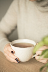Woman hands holding cup of tea