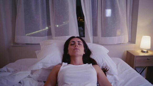 A woman lies on a hotel bed staring at the ceiling as soft violet light fills the room. Curtains sway slowly in the air conditioning. Cinematic live-action, pastel lighting, hazy lens effect, Coppola 