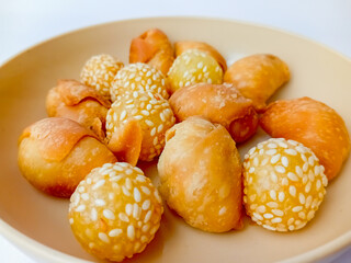 Onde-onde and Molen Pisang, Indonesian traditional snack, served on a round plate, isolated on white background.