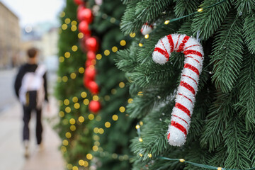 New Year decorations in city, candy cane blurred golden lights on a street on people background