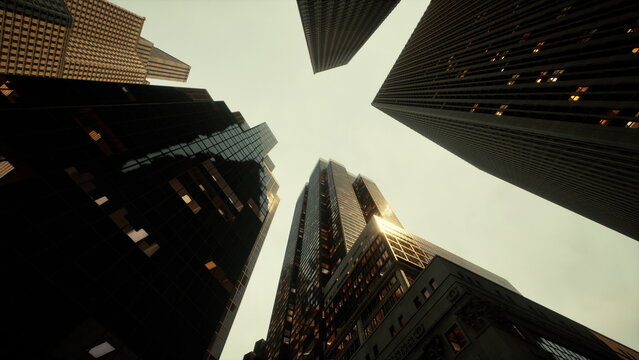 Tall buildings tower overhead as the sun sets, illuminating windows that reflect the evening glow. The skyline creates a dramatic and captivating atmosphere, capturing urban life and energy.