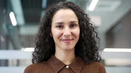 Portrait of a smiling businesswoman at a workplace in a modern business office. Headshot of happy confident woman employee posing looking at camera. Successful friendly female manager. Close up