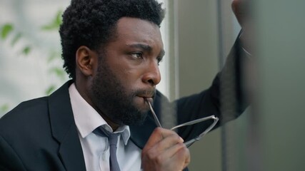 Worried anxiety African American man business guy male businessman stressed thinking solution take of glasses leaning glass of window in office problem think job trouble stress work failure decide - Powered by Adobe