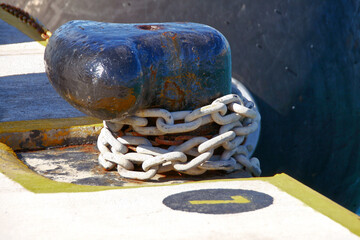 white Rusty Chain Wrapped Around black  Dock Bollard