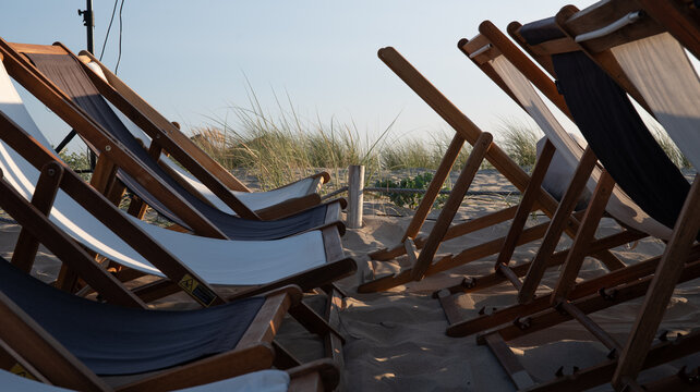 Empty deck chairs on sandy beach, summer holiday relaxation