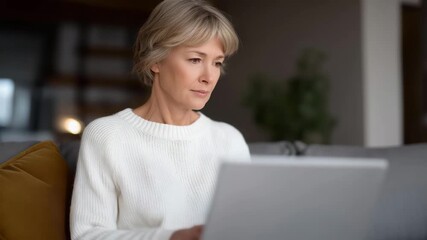Older woman writing her memoirs or farewell message on a laptop in a peaceful home setting, highlighting personal legacy, online remembrance creation, and the intersection of technology and