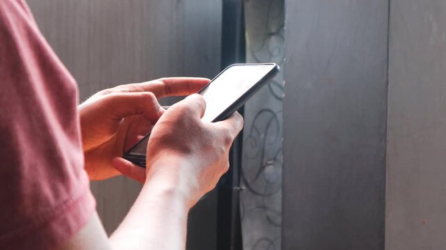 Asian man is typing on a smartphone secretly in the corner