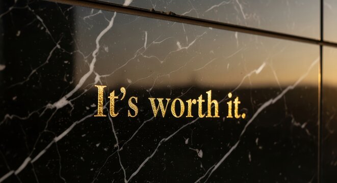 Golden inspirational quote on black marble surface in natural light